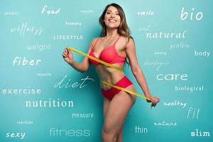 Girl measures with the meter the diet results. Happy and joyful expression. Cyan background with diet terms photo