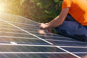 Workers assemble energy system with solar panel for electricity and hot water photo