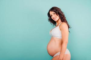 Pregnant happy woman expecting a child caresses her belly photo