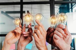 Teamwork and brainstorming concept with businessmen that share an idea with a lamp photo