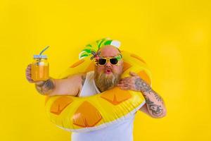 Fat amazed man with wig in head is ready to swim with a donut lifesaver photo
