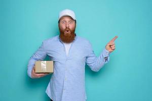 Courier with wondered expression about a great promotion. cyan background photo