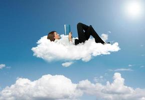 Businesswoman reading a book in a cloud photo