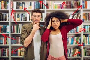 Young student with worried expression in a library photo