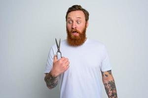 Wondered man with scissors is ready to cut the beard photo