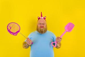 fat man with headband play with sea net and paddle photo