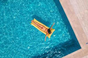 Girl in swimsuit who tan in a swimming pool photo