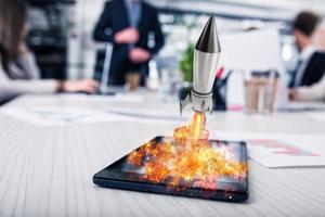 Rocket ready to starts from a tablet. concept of company startup photo
