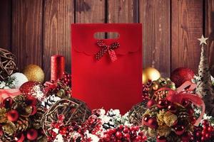 Christmas gift box presented in the middle of Christmas decorations on wooden planks photo