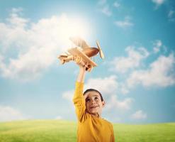 Kid plays with a wooden toy airplane photo