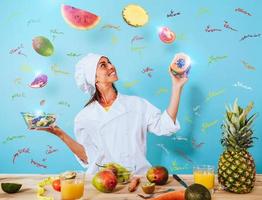 Woman chef prepares a new receipt with fruits photo