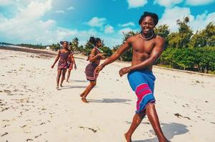 Local group of people with typical kenyan clothes dancing on the beach photo