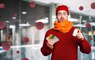 Boy caught a cold and uses pills to heal. Studio on Cyan background photo