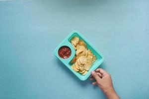 a bowl of chips and salsa on table , photo