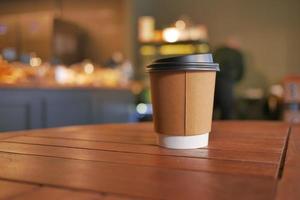 take away paper coffee cup o on cafe table photo