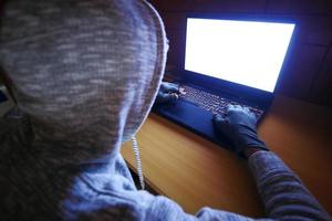 hacker hand stealing data from laptop top down photo