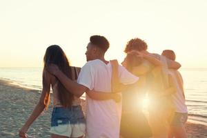 Group of friends having fun on the beach. Concept of summertime photo