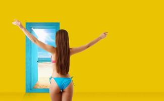 Girl in bikini goes to the beach through a door in the wall photo