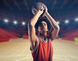 joven africano americano chico con baloncesto tomando un gratis lanzar foto