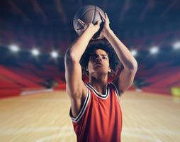 Young African American boy with basketball taking a free throw photo