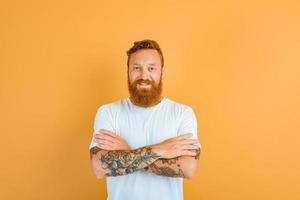 Happy man with beard, tattoo and white t-shirt photo