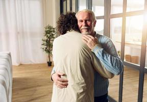 Dad and son hug each other at home. Concept of family relationship photo