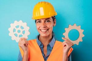 Woman with helmet join pieces of gears as concept of partnership and integration photo
