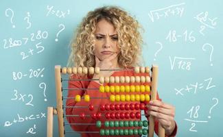 Girl with abacus is confused about the sum . cyan background photo