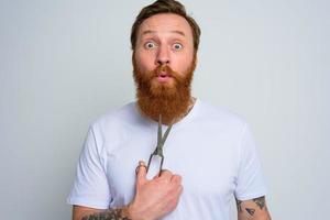 Wondered man with scissors is ready to cut the beard photo