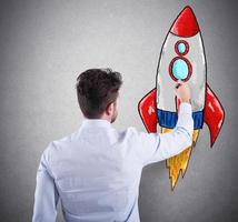 Businessman drawing a rocket. Concept of business improvement and enterprise startup photo