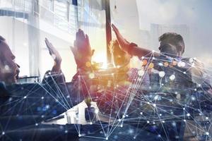 Business people putting their hands together. Concept of startup, integration, teamwork and partnership. Double exposure with internet network effects photo