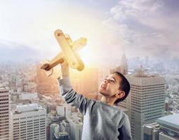 Kid plays with a wooden toy airplane photo