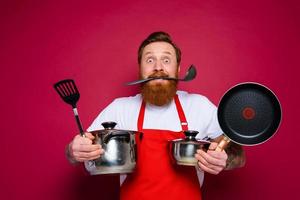 asustado cocinero con barba y rojo delantal es Listo a cocinar foto