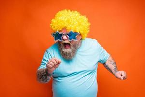Fat man with beard, tattoos and sunglasses sings a song photo