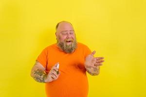 contento hombre con barba y tatuajes sostiene un manos limpiador en contra covid19 foto