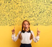 Young student is with shocked expression and indicates a complex exercise. Yellow background photo