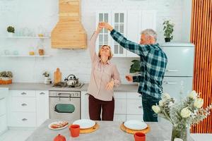 husband and wife dance at home during breakfast photo