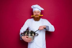 Happy chef with beard and red apron is ready to cook photo