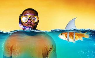 Man with snorkeling mask is scared to go underwater. yellow background photo