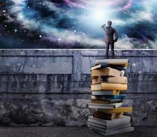 empresario terminado un pila de libros observar el universo lleno de cielo. el cultura abierto el imaginación foto