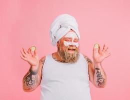 Man with beard acts like a woman and has fun with a facial mask photo