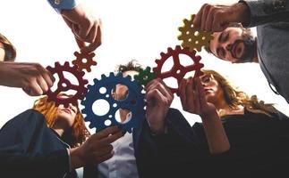 Business team connect pieces of gears. Teamwork, partnership and integration concept photo