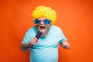 Fat man with beard, tattoos and sunglasses sings a song photo