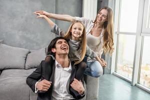 Happy little girl play with her mother and father photo