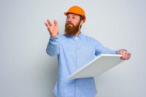 confidente arquitecto con barba y naranja casco lo hace un bosquejo foto