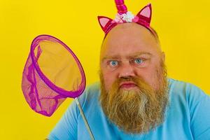 Fat thoughtful man with headband play with sea net photo