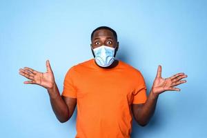 Boy with face mask has a lot of question about covid 19. cyan background photo
