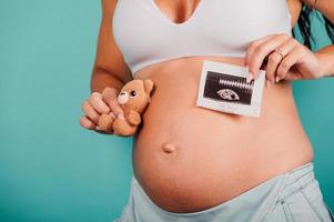 Pregnant mom shows an ultrasound of her son photo