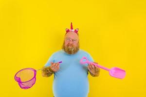 fat man with headband play with sea net and paddle photo