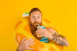 man with life buoy of child drinks a fruit juice photo